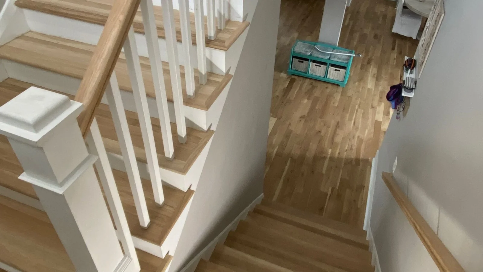 Hardwood staircase with white painted handrail, balusters, and risers on natural wood treads