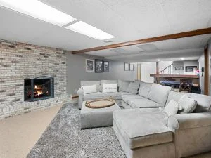 Light hardwood flooring in modern living room with fireplace and gray sectional sofa