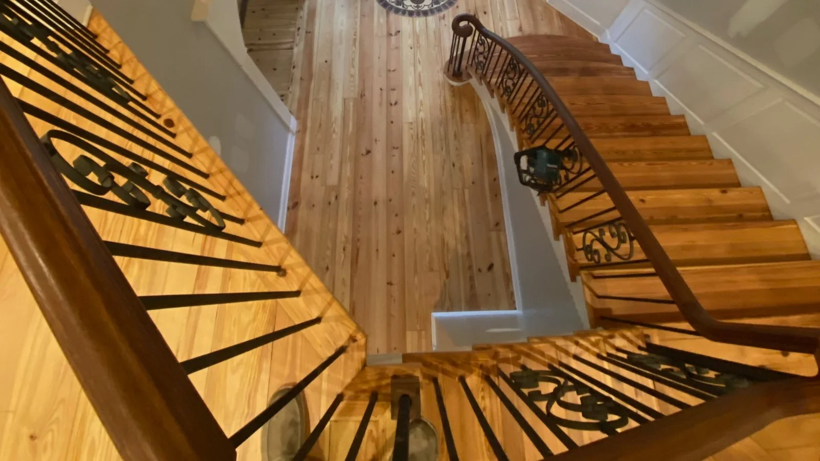 Refinished hardwood staircase with 9 steps, wrought iron railings, and natural wood finish